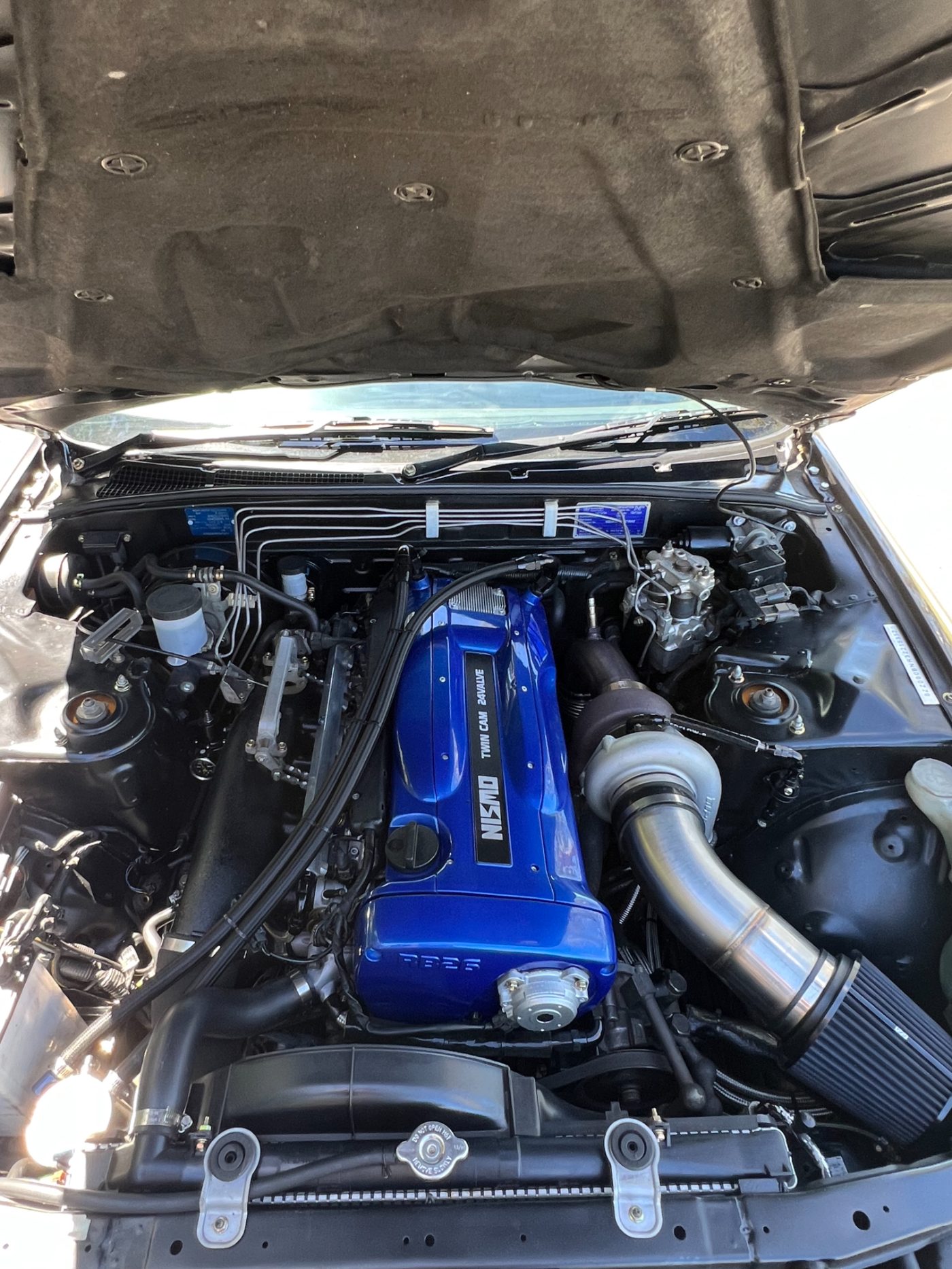 Built RB26 engine bay after the BNR build, NISMO blue valve cover